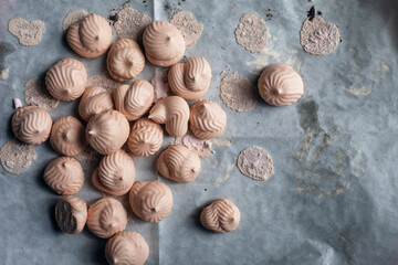 Pink meringues on baking parchment
