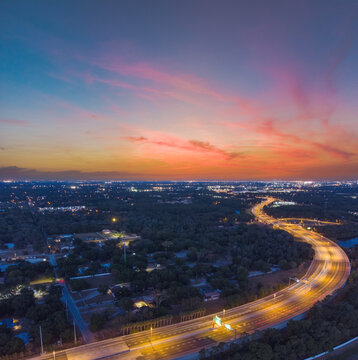 Beautiful long exposure sunset taken at dusk in Tampa, Florida with amazing clouds, car light trails on the highway, and pastel colors.