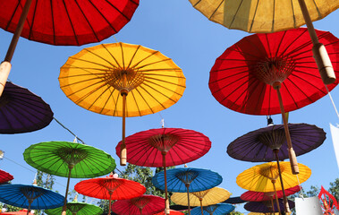 Fototapeta na wymiar Under side of handmade paper umbrellas with blue sky background. 