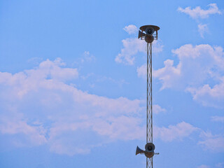 A loudspeaker mounted on a broadcast tower.