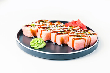 Pink sushi roll in black plate on white background. Japanese food.