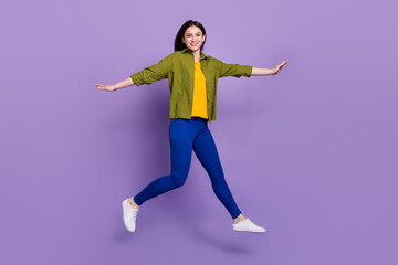 Fototapeta na wymiar Full length profile side photo of young girl happy positive smile jump up go walk isolated over violet color background