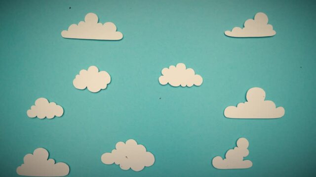 Stop Motion Animation. Paper cut out balloons floating through a blue sky and fluffy white clouds. Old film flicker and grain