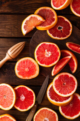 sliced pieces of grapefruit lie on the table on the dark wooden countertop