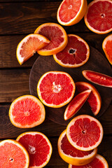 sliced pieces of grapefruit lie on the table on the dark wooden countertop