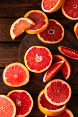 sliced pieces of grapefruit lie on the table on the dark wooden countertop