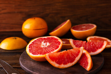 sliced pieces of grapefruit lie on the table on the dark wooden countertop