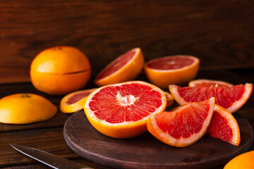 sliced pieces of grapefruit lie on the table on the dark wooden countertop