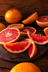 sliced pieces of grapefruit lie on the table on the dark wooden countertop