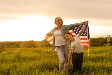 Mother and daughter with American Flag in a beautiful field