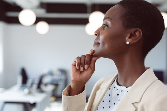 African American Businesswoman Thinking, Touching Chin At Work