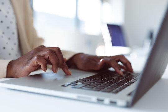 Close up of hands of african american businesswoman using laptop