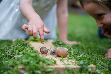 Two toddler kids observing snails