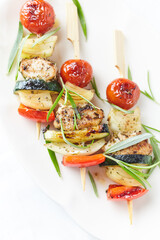 Grilled shashliks with chicken, cherry tomatoes, onion and red pepper. Bright wooden background. Top view. Copy space.	