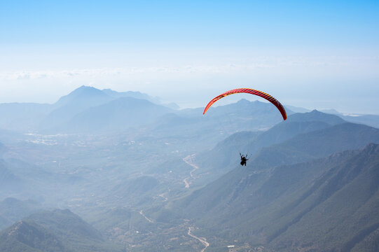 Paraglider flying over mountains