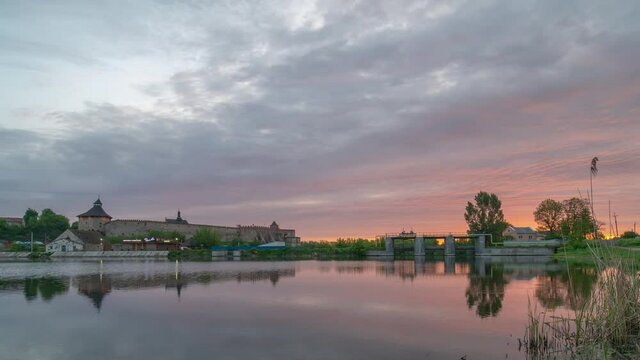 Medzhibozh, Ukraine - may 24 2021: Sunset, sunrise timelapse above the Medzhybizh Castle, Ukraine. Lake and purple clouds. Fortification