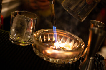 barman blowtorching part of a drinks ornament