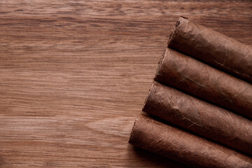 Group of brown cuban cigars on wooden background
