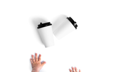 White disposable cups with a black lid isolated on a white background. Child hands. Paper cups.