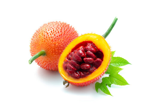 Ripe gac fruit whole and halved, and green leaves isolated on white background. Gac is high in antioxidants that help slow down aging and prevent aging. Strengthen the body's immune system