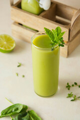 Green smoothie detox drink with apples, spinach, cucumber, lime, bananas.