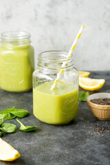 Detox smoothie glass jars. Green healthy drink with spinach,banana, cucumbers, lime and mint.