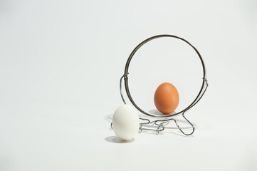 White and brown eggs reflected in the mirror on the white background.