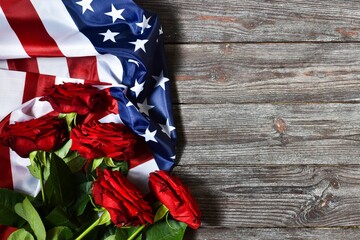 Independence Day USA concept. Memorial Day. Red roses with USA flag on a wooden background. Top view, flat lay with copy space.