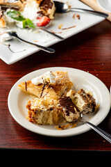 Italian Dessert platter. Cheesecake, très lèches, tiramisu apple tarts, and chocolate cake slices topped with whipped cream and raspberry sauce. Classic Italian restaurant dessert favorites.