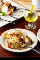 Italian Dessert platter. Cheesecake, très lèches, tiramisu apple tarts, and chocolate cake slices topped with whipped cream and raspberry sauce. Classic Italian restaurant dessert favorites.