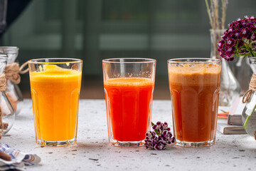 Assorted glasses of fresh fruit juice on light background