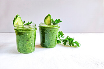 Green cocktail of spinach, lemon, cucumber and parsley on a light background. The concept of healthy nutrition, detox, green, diet, vegan, keto.