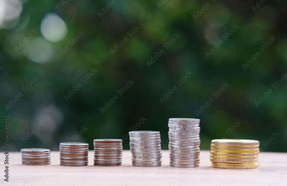 Wall mural Saving money concept, stacking coins on green bokeh background, Advertising coins of finance and banking 