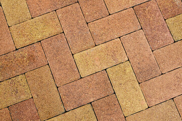 Naklejka premium Stone block pavement. Brown and yellow paving slabs, close up. Pattern of paving blocks, top view