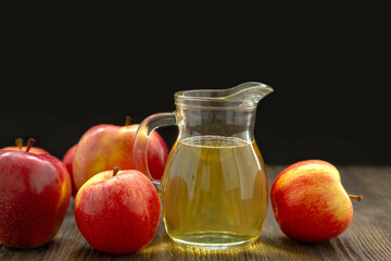 Red apples and cider in a glass jug