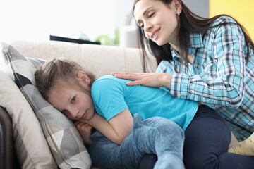 Offended little girl turned away from her mother on couch