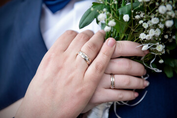 Hands of the bride and groom with gold wedding rings. Wedding concept