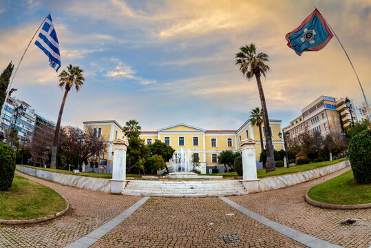 Athens, Attica, Greece. Τhe Municipality of Athens Cultural Centre building panoramic view. Garden with palm trees, fountain at the courtyard. Greek and Municipality of Athens' flags