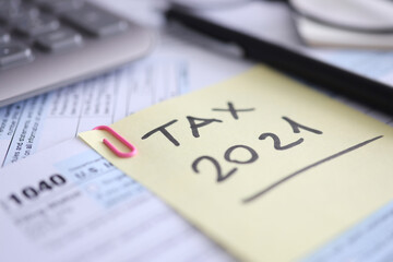 Tax form for 2021 calculator and document are on table