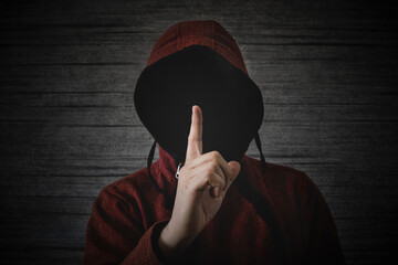 unknown person without a face in a hood shows a finger gesture meaning towns. The concept of...