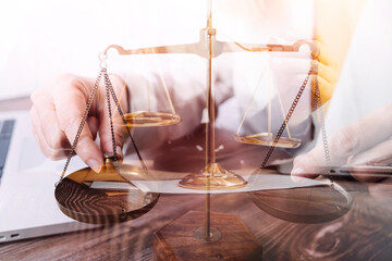 Justice and law concept.Male judge in a courtroom with the gavel, working with, computer and docking keyboard, eyeglasses, on table in morning light