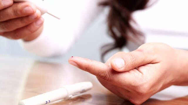 Close up of woman using glucose meter testing on centration of glucose in blood. Concept of World Diabetes Day, Glycemia, Hypoglycemia, Hyperglycemia, Insulin, Healthcare and Medical.