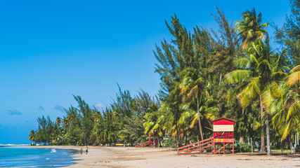 Red Life guard hut and palm trees on tropical beach. Luquillo Beach, Puerto Rico