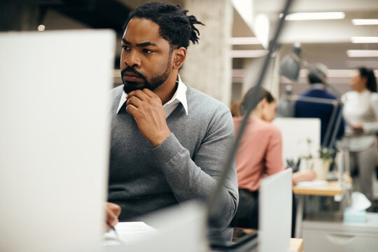 African American Entrepreneur Taking Notes While Working On A Computer In The Office.