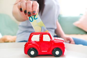 young woman puts money in a piggy bank