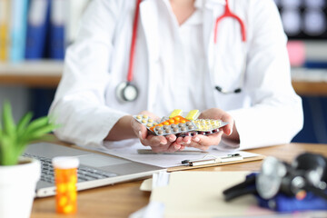 Female doctor is holding various medications in her hands