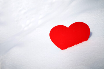 Fototapeta premium Heart made of felt in the snow, in a snowdrift. The symbol of unrequited love or the holiday of lovers. Winter background