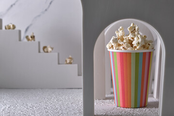 Striped paper cup with popcorn in a decorative arch