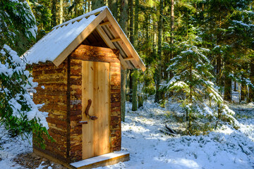 small wooden toilet house in the forest woods - Powered by Adobe