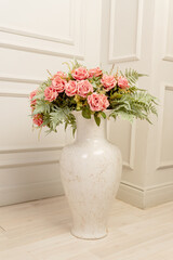 bouquet of pink roses in floor ceramic vase in classic style. Shbby chic interior decoration.